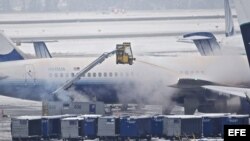 Personal limpia la nieve sobre un avión de United Airlines