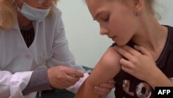 Niña recibe vacuna contra el sarampión