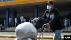 Un cubano residente en Estados Unidos arriba cargado de paquetes al Aeropuerto Internacional José Martí de La Habana. ( Yamil LAGE / AFP)