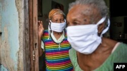 Ancianas cubanas protegidas con mascarillas. (Yamil Lage / AFP).