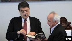 El escritor nicaragüense Sergio Ramírez (i) firma un libro a su colega hondureño Julio Escoto (d).