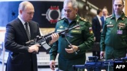 Vladimir Putin revisa armas junto a su Ministro de Defensa Serguei Shoigu (Foto de Mikhail METZEL / SPUTNIK / AFP)
