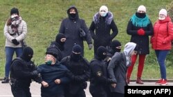 Agentes enmascarados y vestidos de negro reprimen las protestas realizadas en Minsk el 15 de noviembre de 2020 (Stringer / AFP).