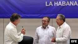 El líder de las FARC, Rodrigo Londoño Echeverri, alias "Timochenko" (c), habla con los presidentes de Cuba, Raúl Castro (d), y de Colombia, Juan Manuel Santos (i), en La Habana.