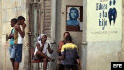  Varias personas conversan junto a un retrato del Che Guevara en La Habana (Cuba). 