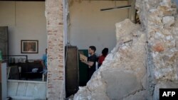 Una familia cubana recoge sus pertenencias en su casa destruida por el tornado.