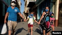 Una familia cubana con protección en medio de la pandemia, en marzo de 2020. (REUTERS/Alexandre Meneghini).