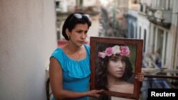 Heissy Celaya posa con un retrato de su hija Amanda Celaya, detenida por la policía durante una protesta, en La Habana, Cuba, el 20 de julio de 2021. Fotografía tomada el 20 de julio de 2021. REUTERS / Alexandre Meneghini