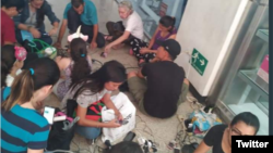 Usuarios venezolanos tratan de cargar baterias de sus celulares en un centro comercial en Caracas