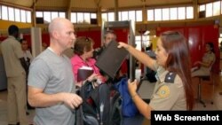 Una funcionaria de la Aduana General de la República de Cuba revisa los artículos que intenta ingresar al país un recién llegado.
