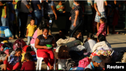 Migrantes venezolanos en Arauquita, Colombia, entre ellos mujeres y menores de edad, acampan en una estación temporal tras enfrentamientos militares en Venezuela en el mes de abril de 2021.