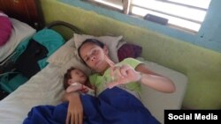 Bárbara Farrat Guillén, madre del preso del 11J, Jonathan Torres Farrat, con su nieto en brazos. (Foto: Facebook)