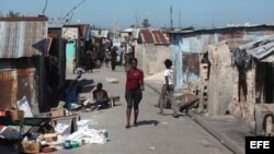Una mujer caminia por un barrio en Puerto Principe, Haití.