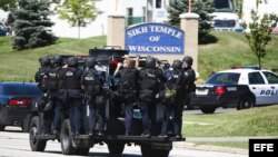 Un vehículo de la Policía transporta a varios oficiales, tras un tiroteo en un templo de la comunidad sij en Oak Creek, estado de Wisconsin, EE.UU.