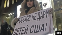 Una mujer protesta en contra de la prohibición de adopción de huérfanos rusos a ciudadanos americanos a las puertas del Consejo de la Federación en Moscú (Rusia).