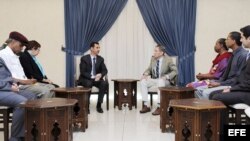 Fotografía cedida por la agencia siria de noticias SANA que muestra al presidente sirio, Bachar al Assad (c-izda.) durante la reunión que mantuvo con una delegación estadounidense encabezada por el ex fiscal general Ramsey Clark (c-dcha.) en Damasco, Siri