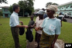 Sacerdote entrega ayuda humanitaria a comunidadd en Monrovia