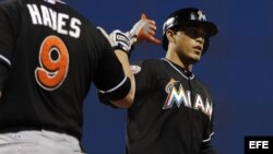 Giancarlo Stanton (d) de los Marlins de Miami es felicitado por Brett Hayes (i) tras batear un jonrón.