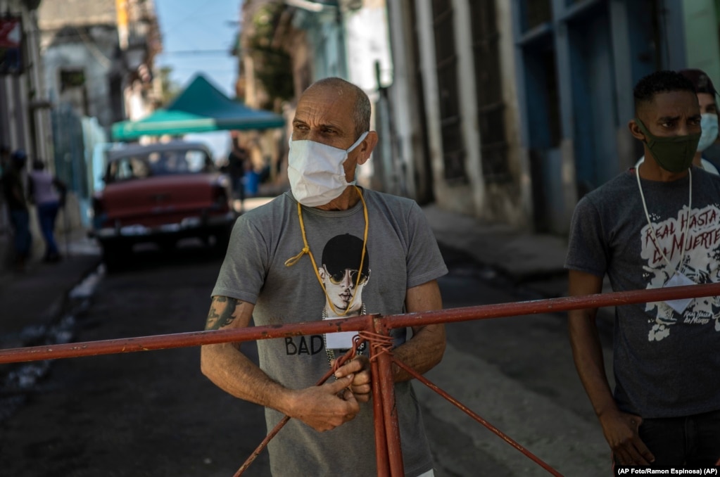 Männer stehen Wache an einem Zaun, der den Zugang zu ihrem wegen eine Coronavirus-Ausbruchs abgesperrten Viertel verwehrt (22. Februar 2021). | Bildquelle: Radio Televisión Martí | Bilder sind in der Regel urheberrechtlich geschützt