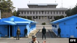 Soldados surcoreanos (de espaldas a la cámara) observan a un soldado norcoreano (al fondo, entre las columnas) en la zona desmilitarizada donde en 1953 se firmó el armisticio entre las dos coreas en Panmunjom (Corea del Sur) hoy, jueves 28 de marzo de 201