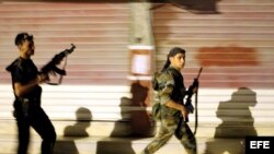 Rebeldes sirios patrullan por las calles de Alepo, Siria.
