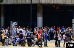 Venezolanos esperan frente a una estación del metro, en Caracas, durante un apagón que afectó a gran parte de la capital venezolana.