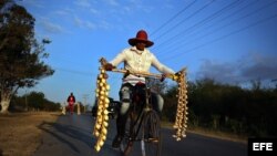  Dos vendedores ambulantes de ajos y cebollas transitan por una carretera rural de Pinar del Río (Cuba).