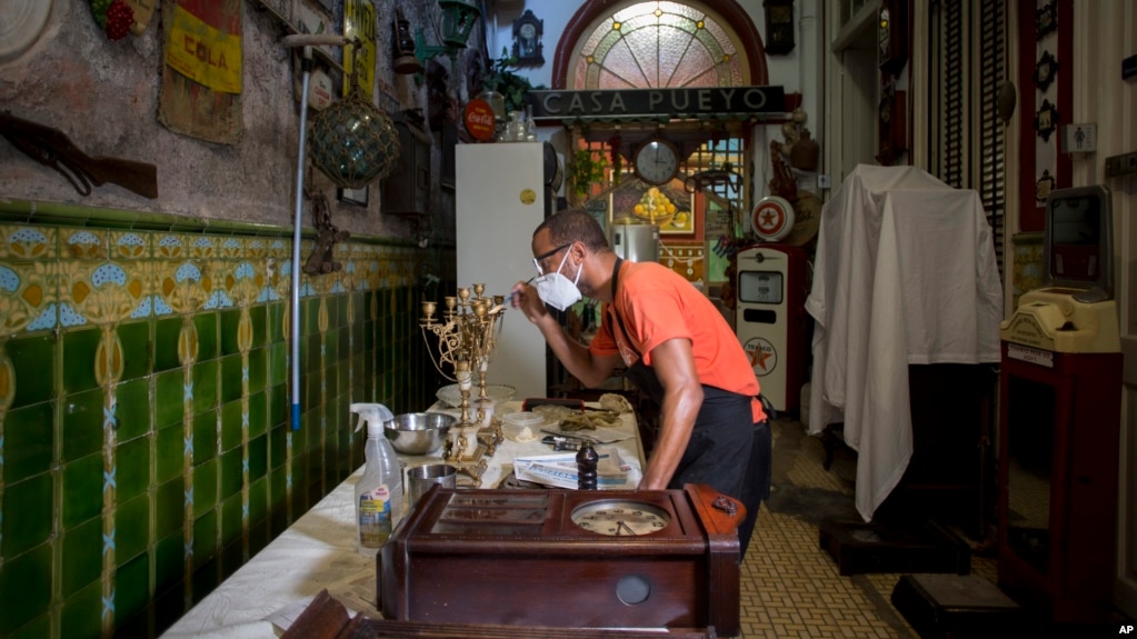 Un empleado del restaurante privado San Cristóbal de La Habana pinta un candelabro. (AP/Ismael Francisco/Archivo)