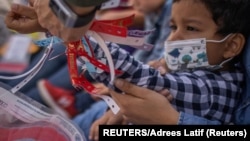 Agente de la Patrulla Fronteriza de EEUU quita pulsera de Santiago, niño de 4 años de Honduras