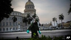 Un soldado limpia con una solución de cloro las calles aledañas al Capitolio de La Habana. (AP/ Ramon Espinosa)