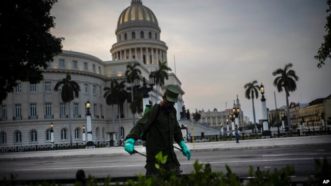 Un soldado limpia con una solución de cloro las calles aledañas al Capitolio de La Habana. (AP/ Ramon Espinosa)