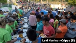Migrantes en Matamoros, México, recibiendo alimentos. (Lexi Harrison-Cripps / AFP).