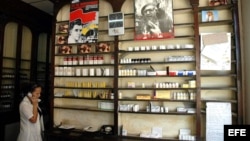 Una dependienta habla por teléfono frente a un estante de una Farmacia.