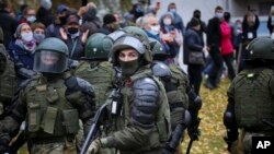 Policías armados impiden el avance de una marcha contra el gobierno del presidente Alexander Lukashenko en Minsk, Bielorrusia. (AP Foto)