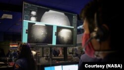 Científicos observan en la Misión de Control del Laboratorio de Propulsión a Chorro de la NASA, en el sur de California, mientras llegan las primeras imágenes, momentos después de que la nave espacial aterrizó. [NASA / Bill Ingalls]