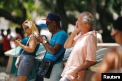 Cubanos conectados a la Internet desde un punto WI-FI en La Habana, Cuba.