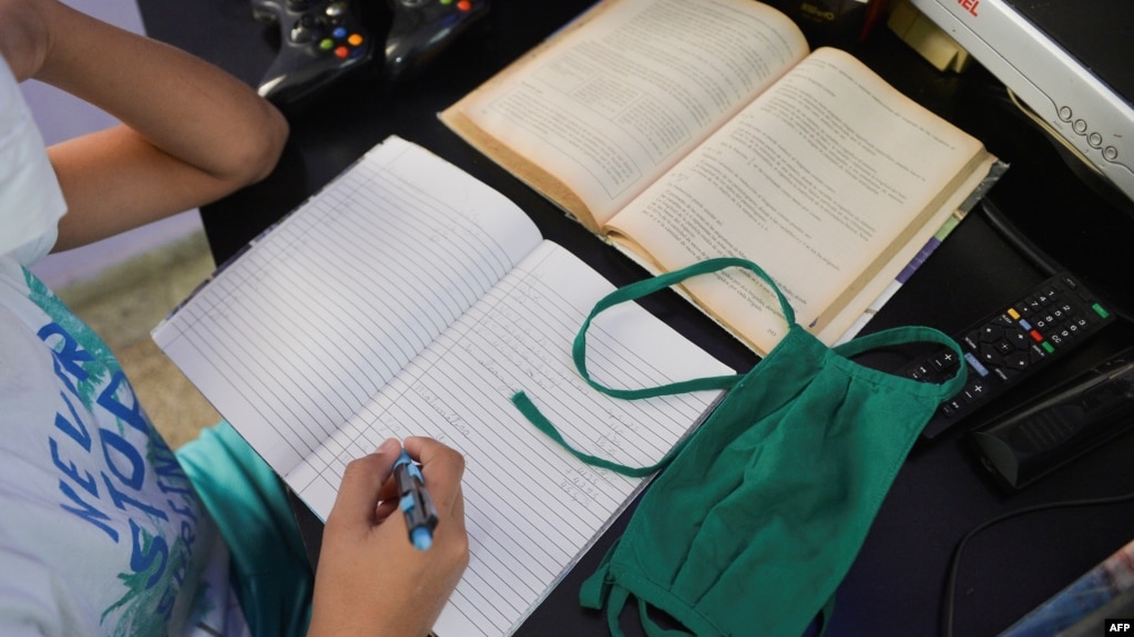 Estudiantes de enseñanza primaria reciben las llamadas teleclases. (YAMIL LAGE / AFP)