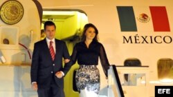 El presidente de México Enrique Peña Nieto (i) desciende junto a su esposa Angélica Rivera, en el aeropuerto internacional José Martí en La Habana (Cuba).
