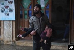 Un hombre sirio lleva en brazos a una niña fallecida en el terremoto, en la localidad de Azmarin, provincia de Idlib, en el norte de Siria. (AP Foto/Ghaith Alsayed)