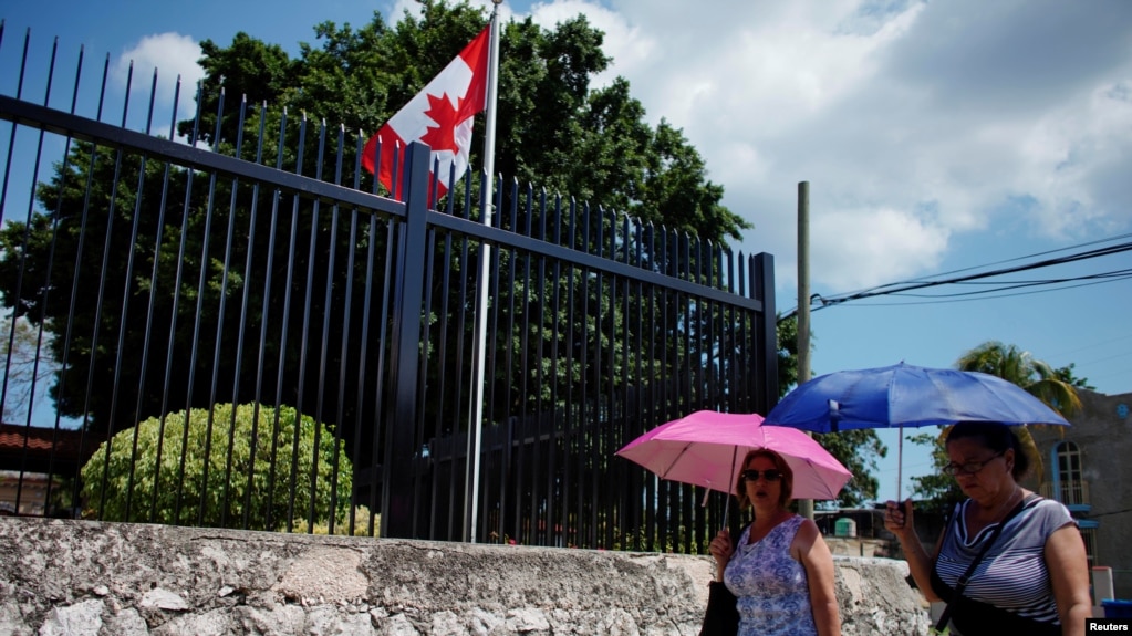 Cubanos caminan frente a la embajada de CanadÃ¡ en La Habana.