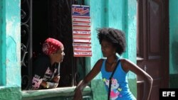 Dos mujeres hablan por la ventana de una cafetería privada en La Habana.