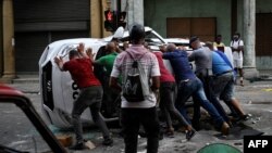 Una patrulla volcada durante el levantamiento del 11 de julio en La Habana. Los manifestantes gritaron "Abajo la Dictadura" y "Queremos libertad" YAMIL LAGE / AFP