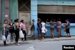 Cubanos hacen fila para adquirir alimentos en una tienda del Estado.