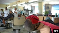 Un cliente se somete a un tratamiento de belleza en una barbería en Santiago de Cuba.