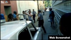 Jorge Anglada Mayeta, amenazado a punta de pistola por un oficial de policía vestido de civil.