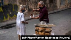 Una mujer compra un dulce a un vendedor ambulante en La Habana. (AP Photo/Ramon Espinosa)