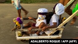 Niños con mascarillas para protegerse del coronavirus durante una celebración religiosa en La Habana. (ADALBERTO ROQUE / AFP)