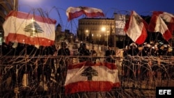 Soldados anti disturbios hacen guardia frente al palacio gubernamental en Beirut, Líbano,