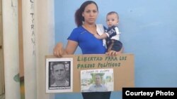 Nelva Ismaray Ortega, con su bebé en brazos y un cartel exigiendo la libertad de su esposo. (Katherine Mojena/CubaNet/Archivo)