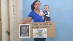 Nelva Ismarays Ortega, con su bebé en brazos y un cartel exigiendo la libertad de su esposo. (Katherine Mojena/CubaNet)